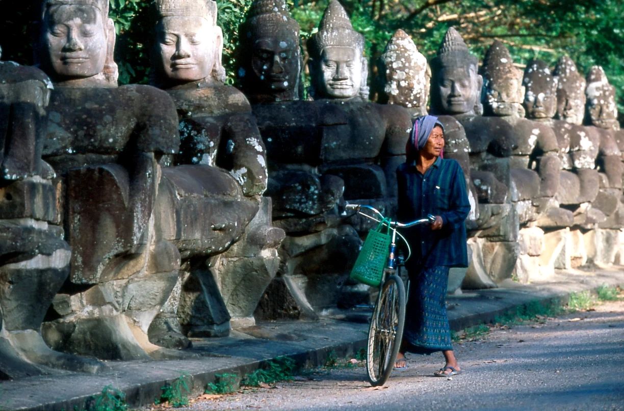 KH - Excursie - Angkor Temples & woman with bike.webp