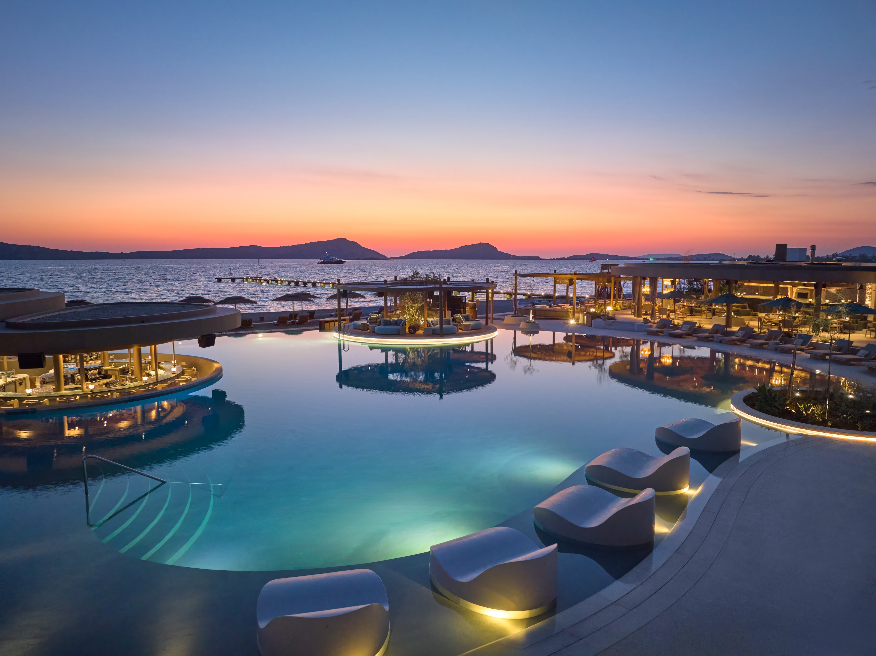 GR - Mandarin Oriental, Costa Navarino - Ormos Beach Club Dusk aerial.jpg
